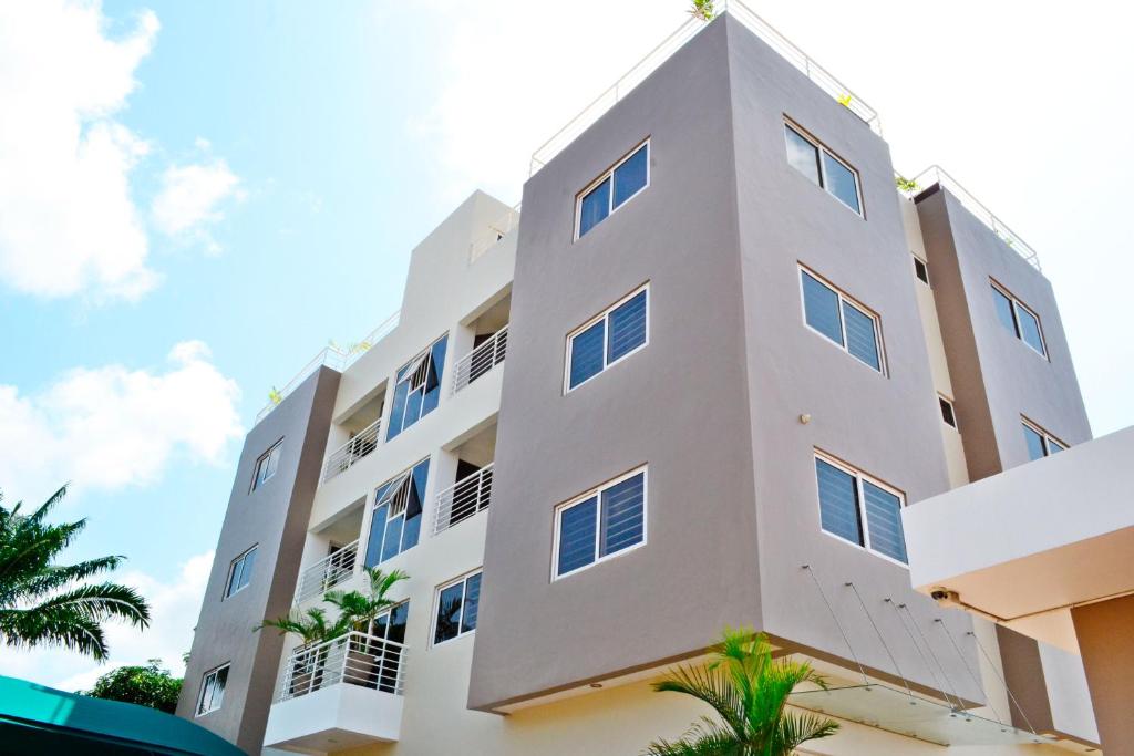 阿克拉Acquah Place Residences的一座白色的建筑,前面有棕榈树