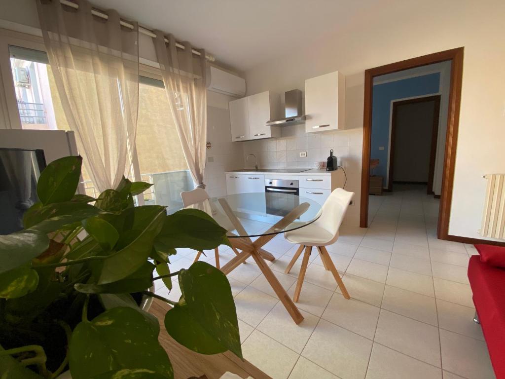 萨萨里Residence La Peonia的一个带玻璃桌和植物的厨房