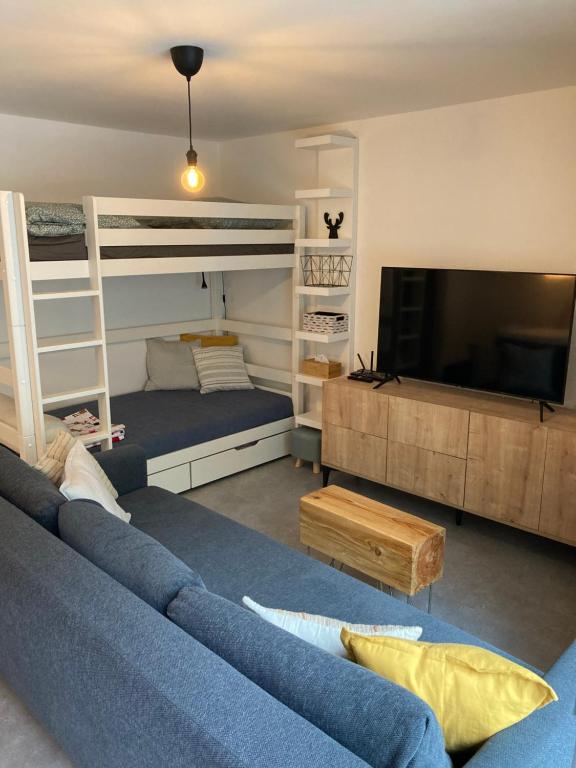 尼萨河畔亚布洛内茨Apartmán U Jelena的客厅配有两张双层床和蓝色沙发