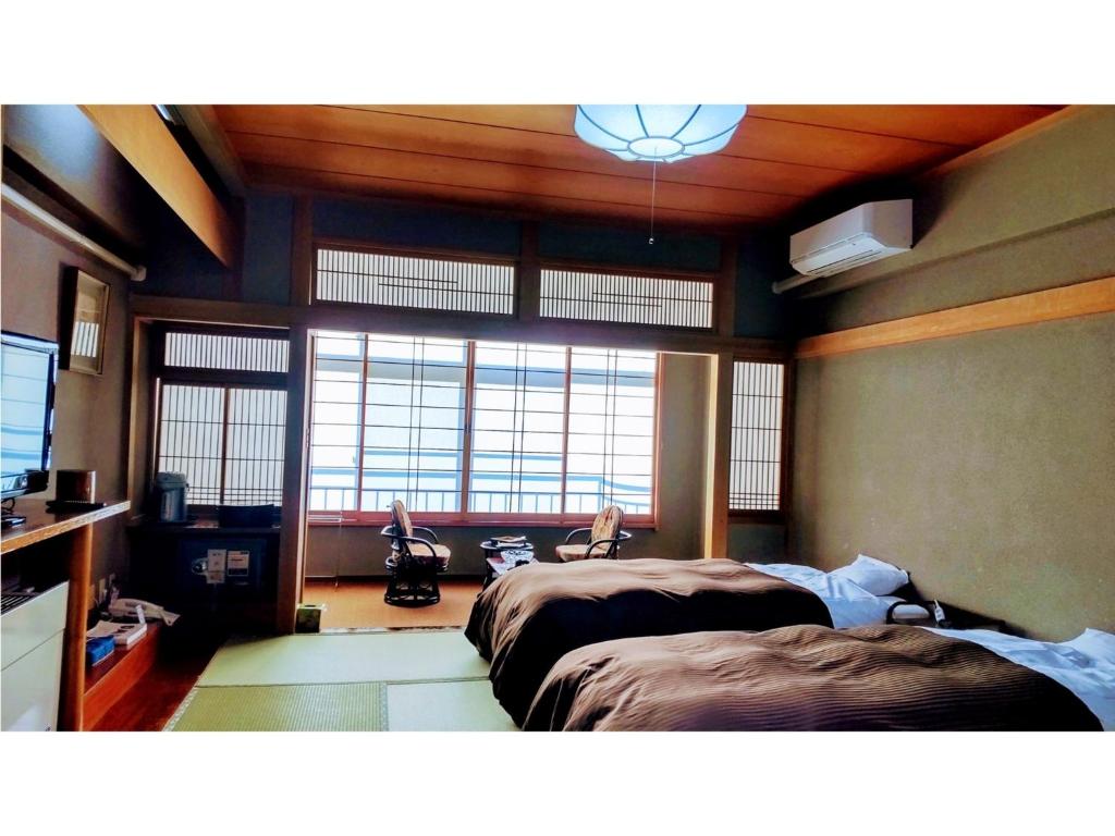 福岛Hotel Tenryukaku - Vacation STAY 16406v的一间卧室设有两张床和大窗户