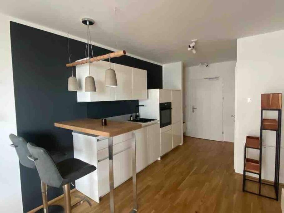 维也纳Moderne Wohnung in der Toplage inkl. Garage的厨房配有白色橱柜和黑色墙壁