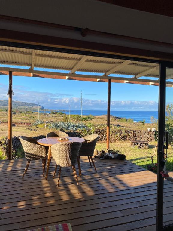 安加罗阿Oasis Rapanui Bungalow frente al Mar的海景甲板上的桌椅