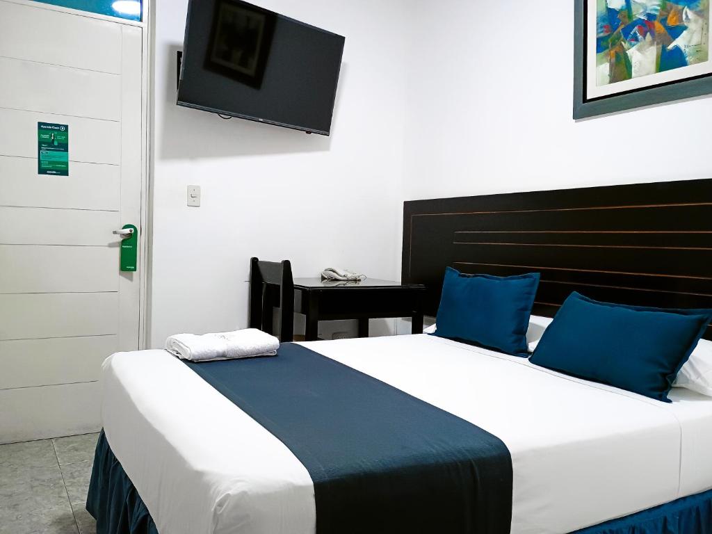 皮乌拉Di Costa Hotel的一间卧室设有两张床,墙上配有电视。