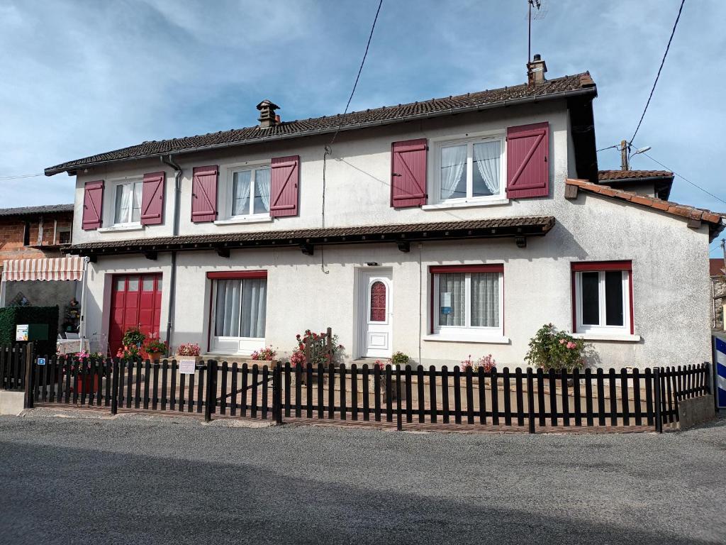 格拉讷河畔奥拉杜尔l'ancienne épicerie的白色的房子,设有红色的窗户和栅栏