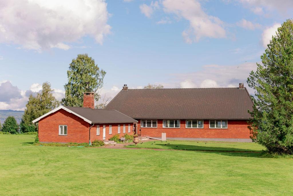 莫拉Bonäs bygdegård的一座红色的房子,位于田野上,有大院子