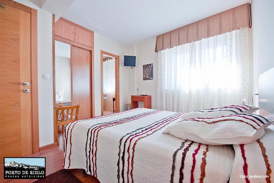 利洛Porto de Rinlo的一间卧室配有带条纹毯子的床