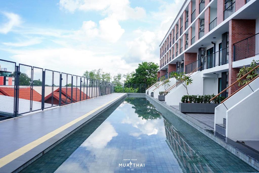 查龙Marina House MUAYTHAI Ta-iad Phuket的一座建筑物中央的游泳池