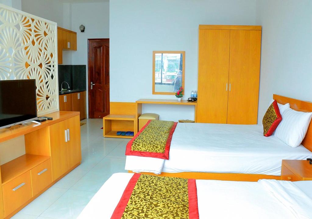 芽庄Khách sạn Phố Ngọc的酒店客房设有两张床和电视。