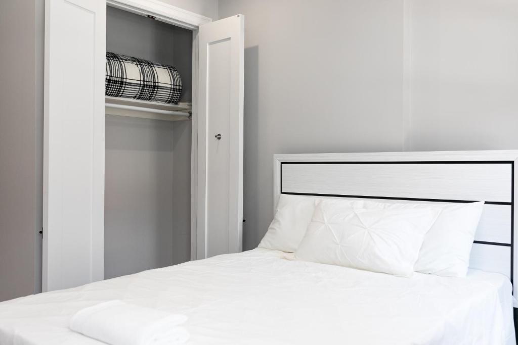 布鲁克林Misbau home的卧室配有白色的床和衣柜。