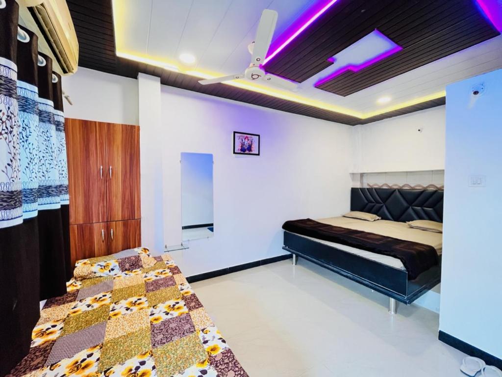 乌贾因PALLAV GUEST HOUSE的一间卧室设有两张床,天花板上配有紫色灯