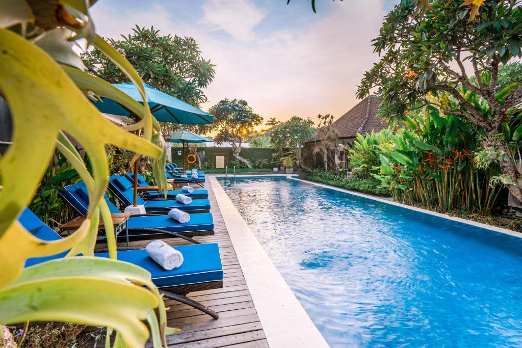 塞米亚克Rama Residence Petitenget的一个带蓝色躺椅的度假村游泳池
