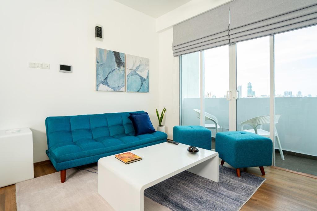科伦坡Hotel Style Colombo Studio Apartment的客厅配有蓝色的沙发和蓝色的椅子
