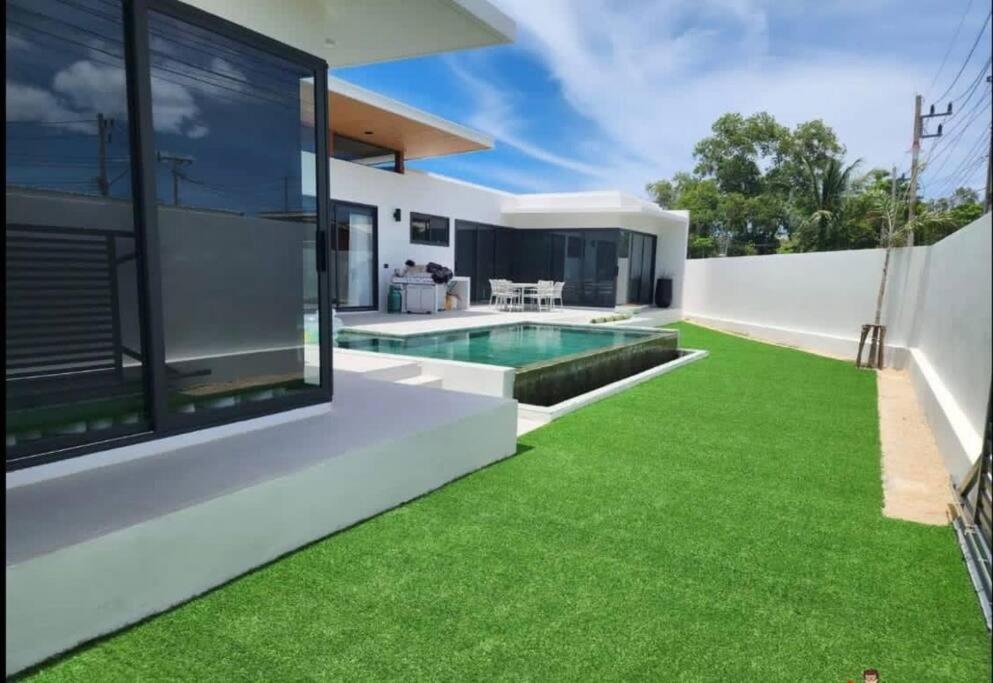 苏梅岛Villa WANNY的一个带游泳池和草地的后院的图像