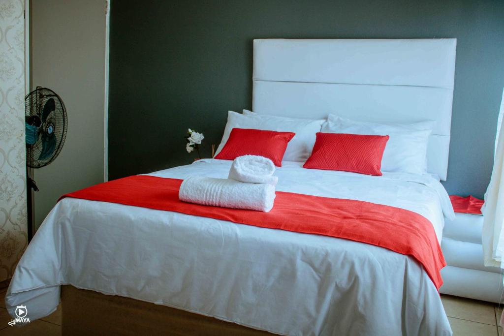 乌姆塔塔BARAKA mtata !的一张带红色枕头和红色毯子的白色床
