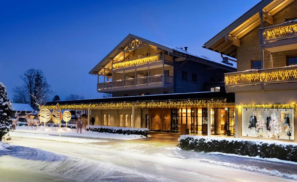 若特阿赫-埃根Parkhotel Egerner Höfe的雪中闪烁的灯笼罩着的建筑