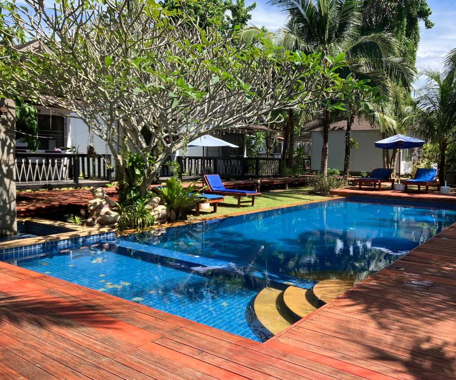 功孟海滩Isle Beach Resort Krabi-SHA的蓝色海水游泳池和木甲板