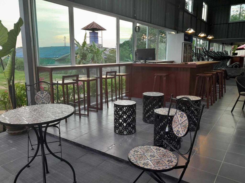 农布Thaineth Sport Camp的一间带桌椅的餐厅和一间酒吧