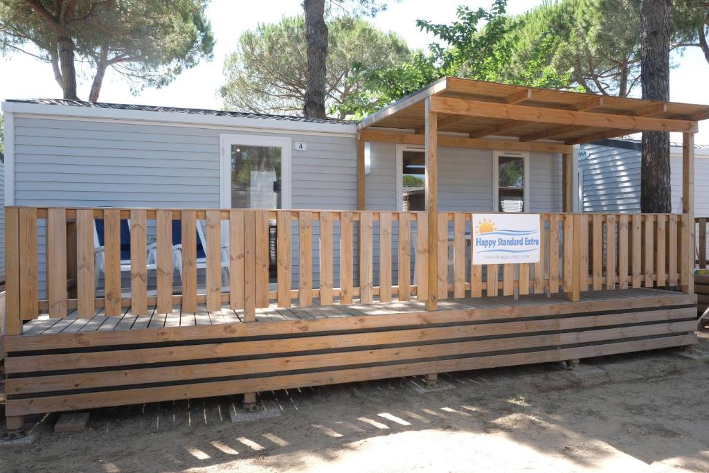 佩斯基耶拉德加达Happy Camp mobile homes in Camping Bella Italia的一座带木甲板的小房子