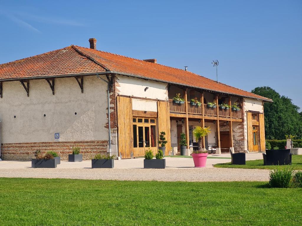 Saint-André-sur-Vieux-JoncDomaine du Cuiset -Gîte des Combles的前面有盆栽植物的建筑