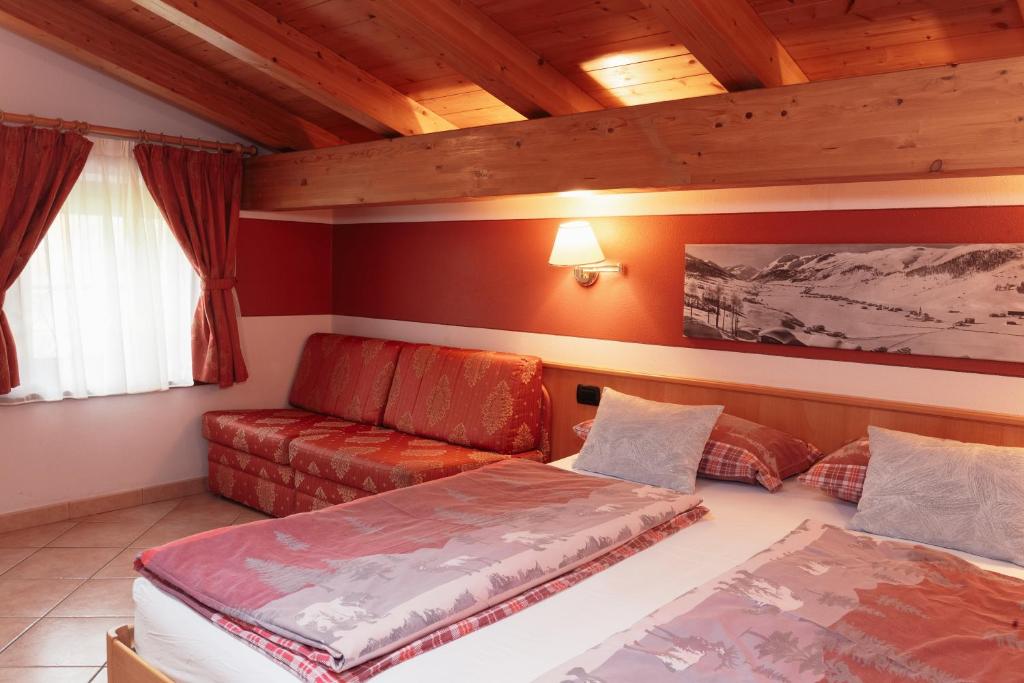 利维尼奥Hotel Garni Rin Da Rin的一间设有两张床和一张沙发的房间