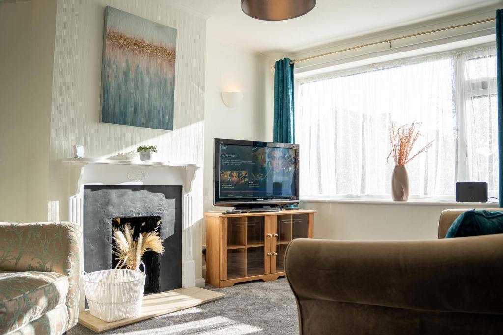 米尔顿凯恩斯Well-furnished 3-Bedroom house with Free Parking and Sky TV in Milton Keynes by HP Accommodation的客厅设有壁炉和电视。
