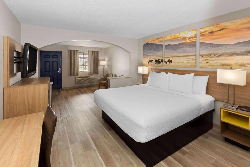 俄克拉何马城俄克拉荷马城戴斯酒店及套房 的一张大白色的床,位于酒店客房内