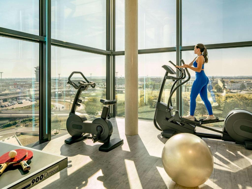 奥利巴黎科尔奥利机场诺富特酒店的一名在健身房跑步机上跑步的女人