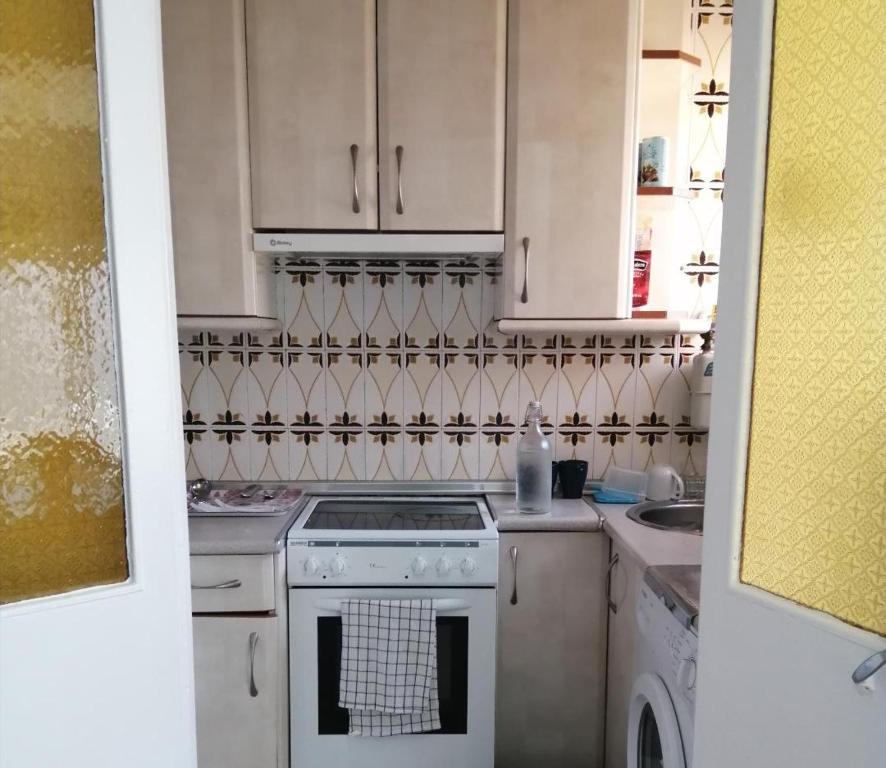 拉·格兰哈·圣·伊尔德La Pequeña Cercona的厨房配有白色橱柜和炉灶烤箱。