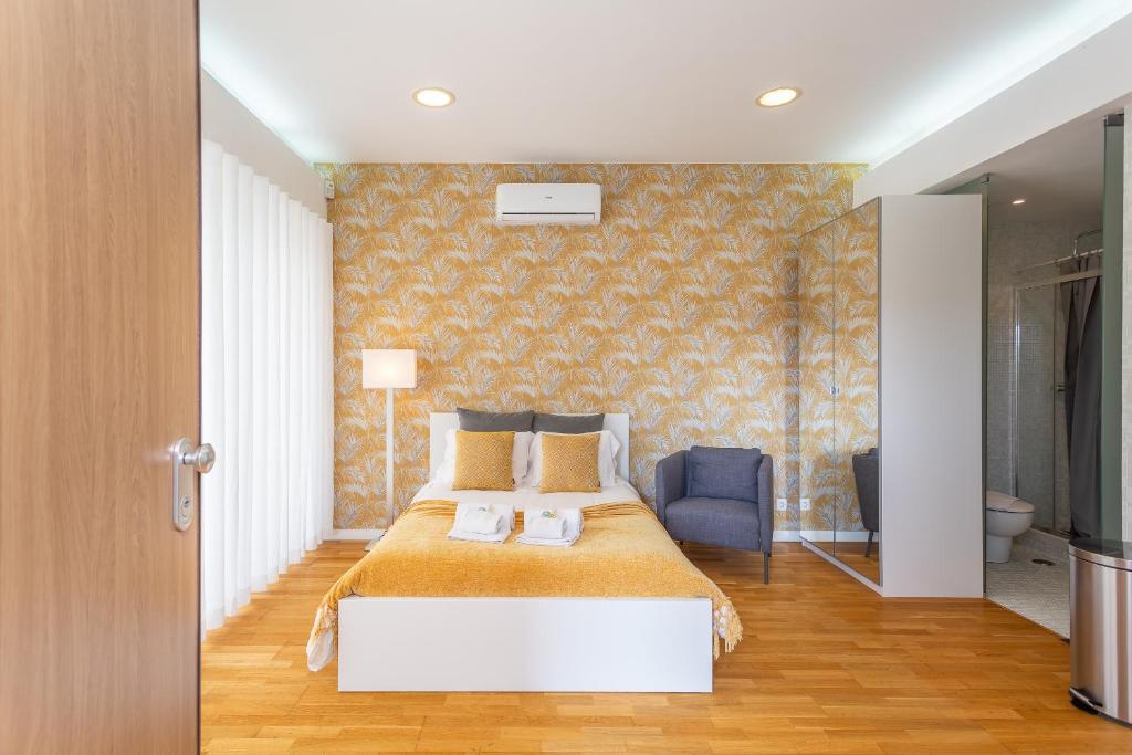 里斯本BeGuest Benfica Modern Flat的一间卧室配有一张大床和一张蓝色椅子