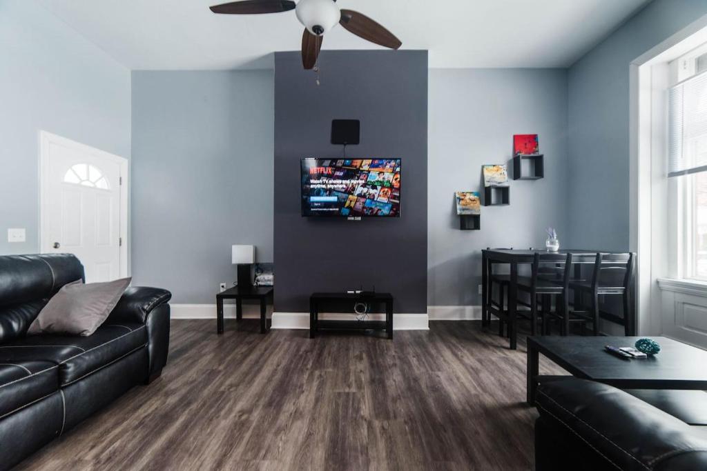 匹兹堡Massive Home - GroupStay - Parking & Location的客厅配有黑色沙发和吊扇