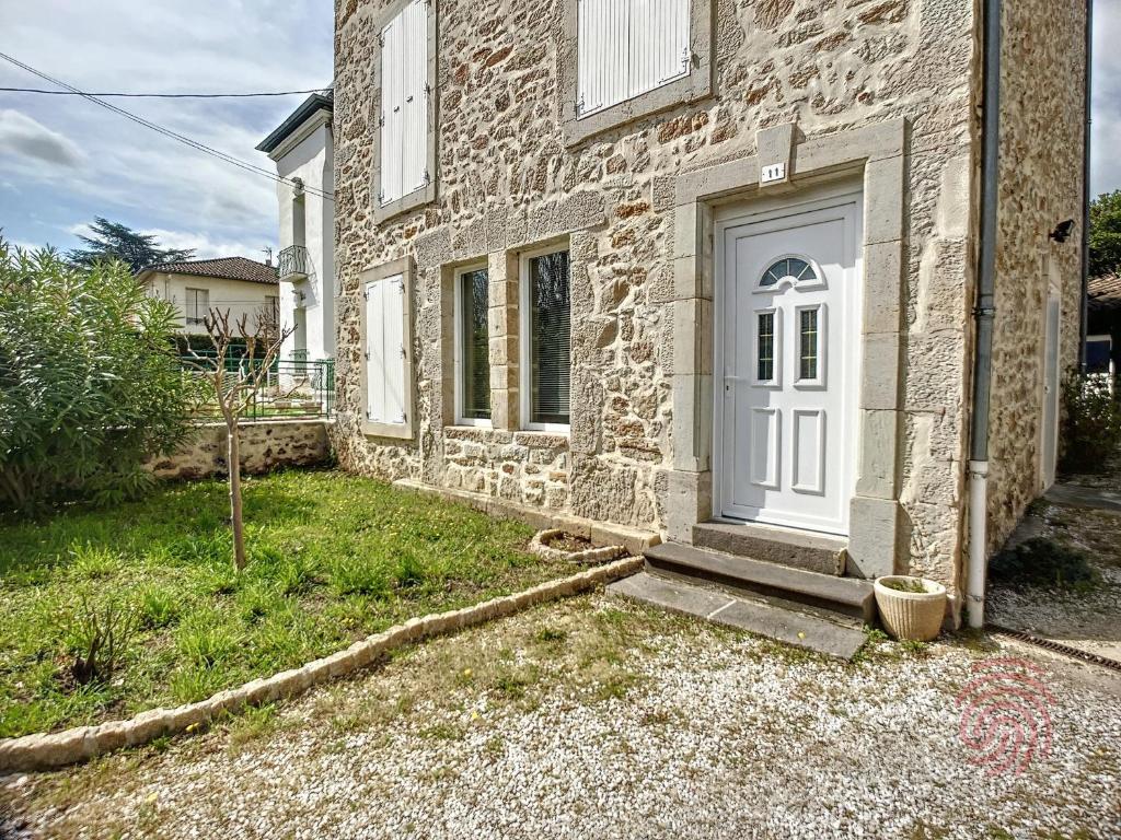 拉马卢莱班Maison Lamalou-les-Bains, 4 pièces, 6 personnes - FR-1-451-45的一座石屋,有白色的门和院子