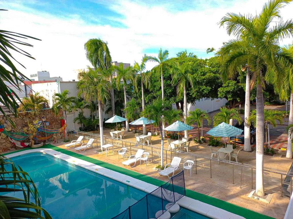 巴耶杜帕尔Vajamar Hotel的一个带椅子和遮阳伞的室外游泳池