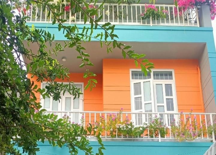 头顿Villa Vũng Tàu - An Thảo Home's的一座橙色和白色的建筑,设有阳台