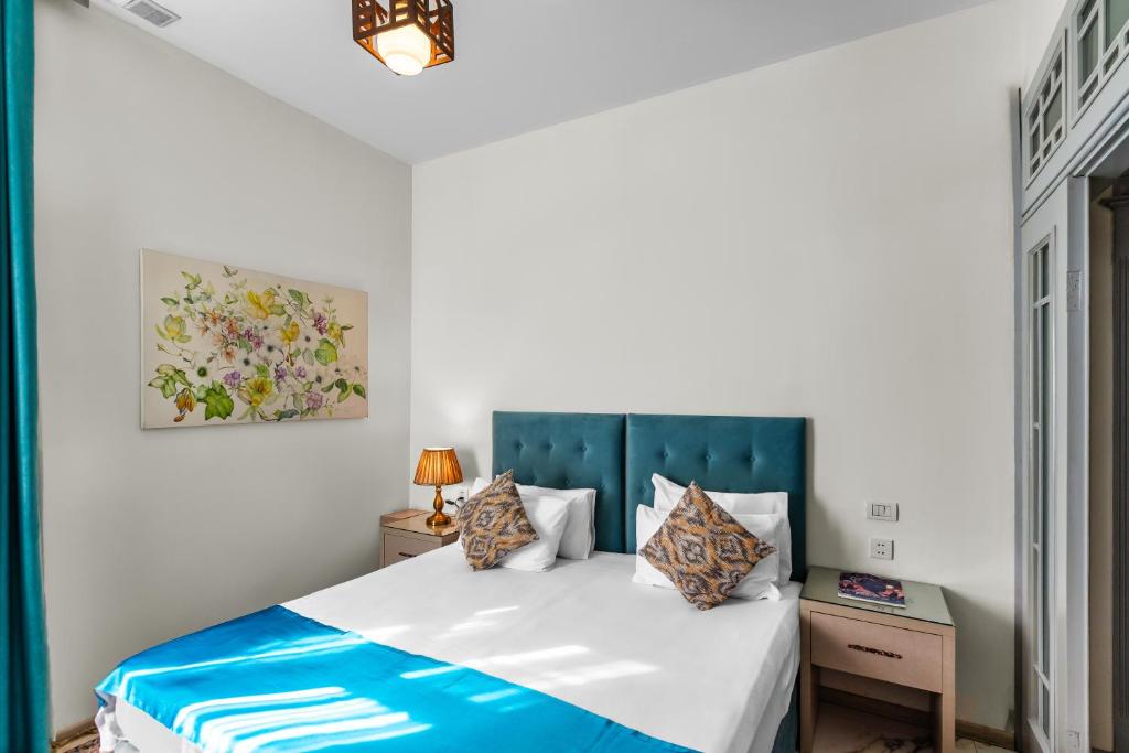 巴库Best Center Boutique Hotel的一间卧室配有一张蓝色床头板的床