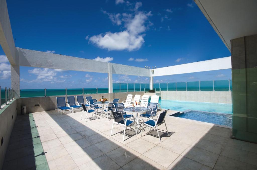 累西腓加戈德罗酒店的游泳池旁带桌椅的天井