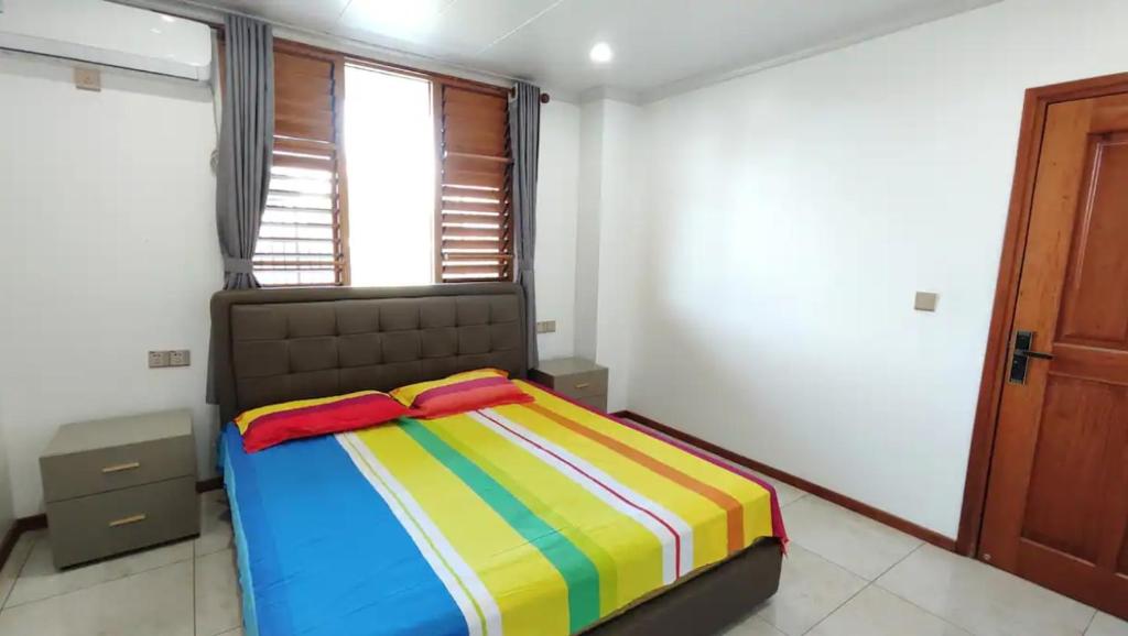 南迪Modern Master bedroom B的一间卧室配有一张带彩色毯子的床