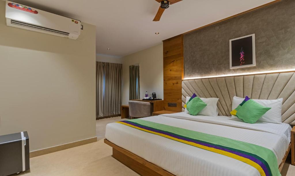 班加罗尔Treebo Trend Tiba的卧室配有带绿色枕头的大型白色床