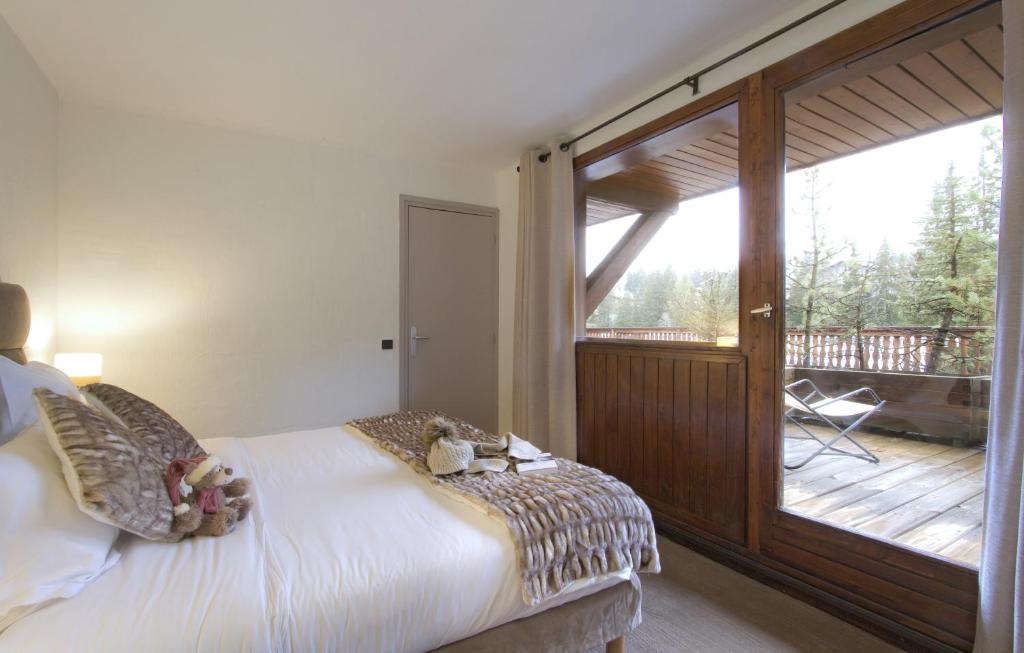 谷雪维尔Odalys Hotel New Solarium的一间卧室配有一张床,阳台配有滑动玻璃门
