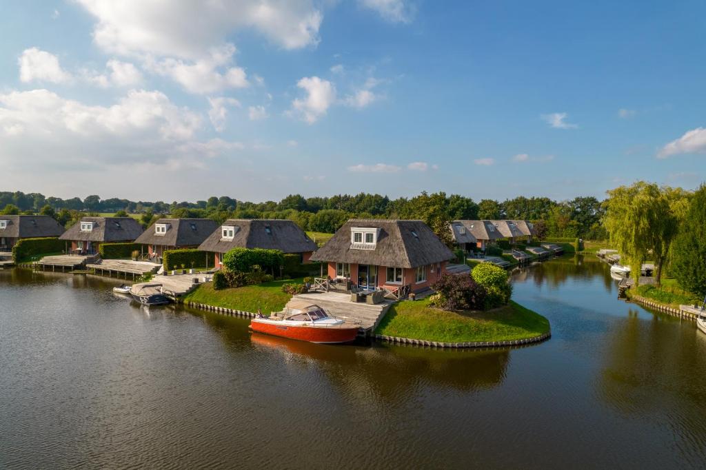 泽伊德拉伦Summio Waterpark De Bloemert的享有河流的空中景致,设有房屋和船只