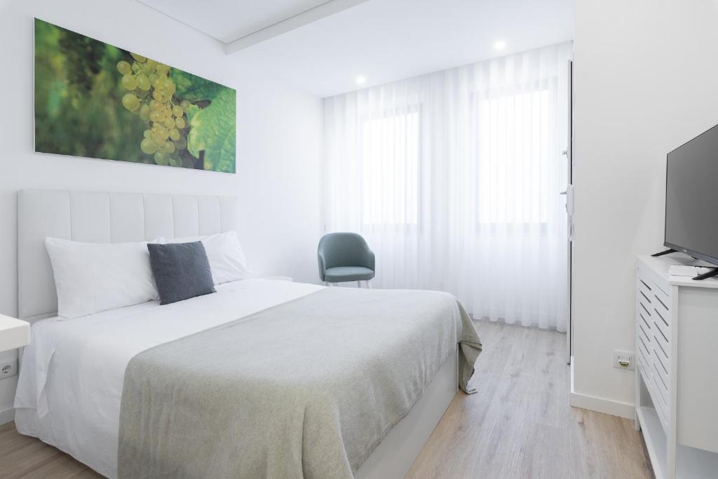 拉梅戈FAFEL LITTLE HOUSE - Quinta de Cravaz的白色卧室配有床和椅子