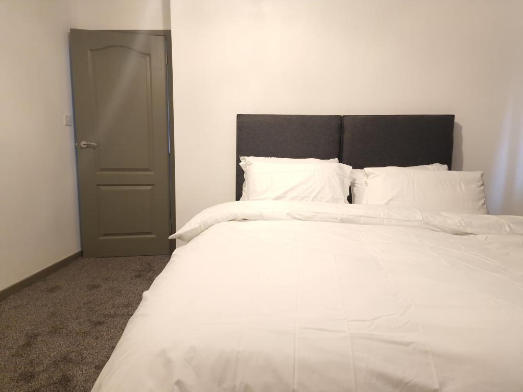 奥尔德伯里Walker Lodge的白色的床、白色床单和黑色床头板