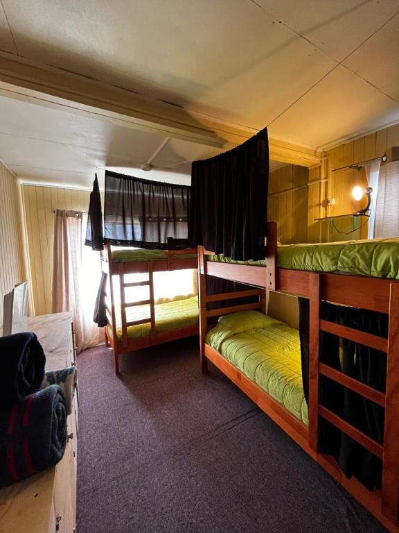 卡斯特鲁La Minga Hostel的带窗户的客房内的两张双层床