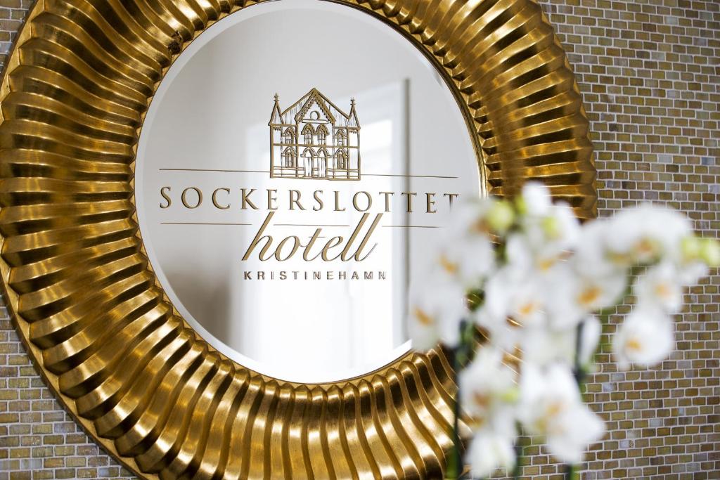 克里斯蒂娜港索克斯洛特酒店的砖墙上的金色镜子,上面有酒店标志