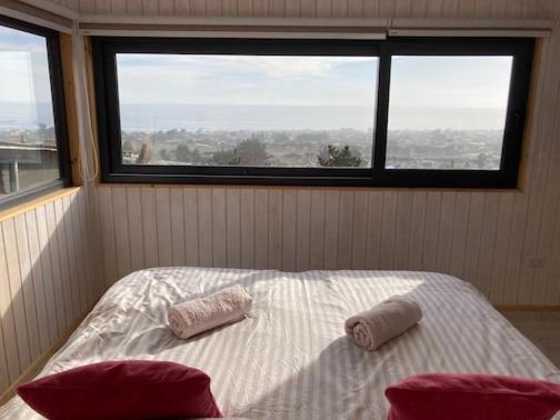 皮奇勒姆Beach escape to Pichilemu - Not so tiny house的一间卧室配有一张带两个枕头的床