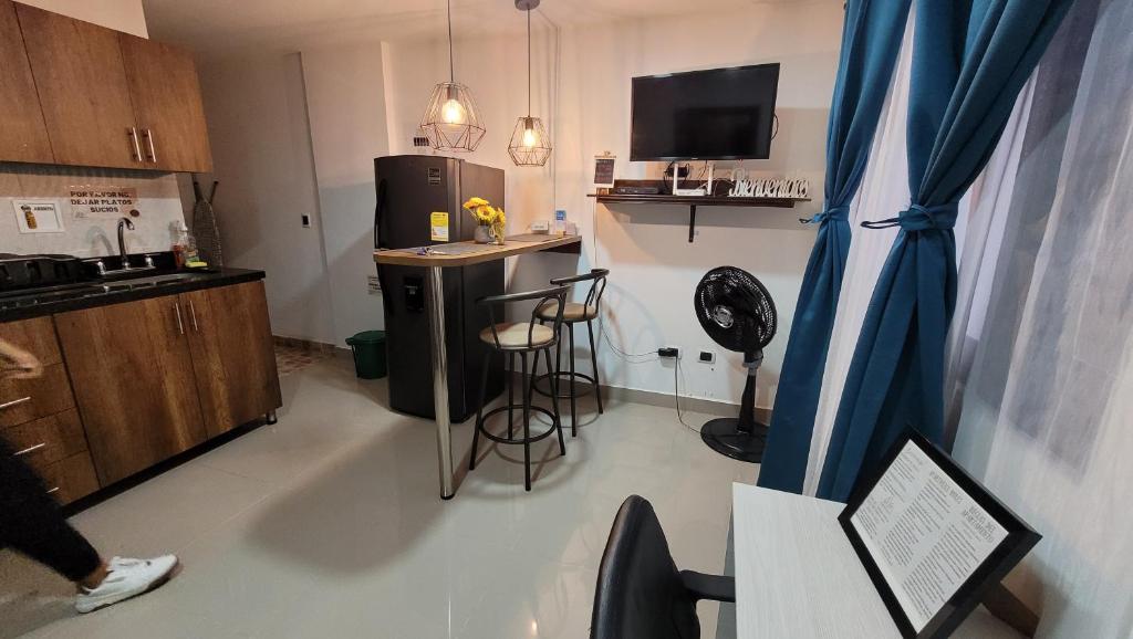 贝约Andaliving Niquia Apartaestudio的客房设有带冰箱和桌子的厨房