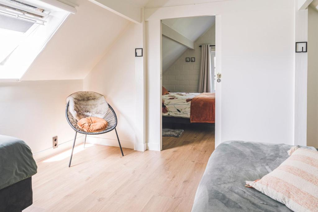 马尔德海姆De Burkelhoeve app.A的一间带椅子的房间和一间带床的卧室