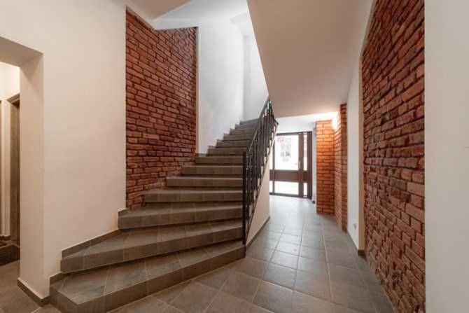 罗兹HOLA Apartamenty Narutowicza的走廊上设有楼梯和砖墙