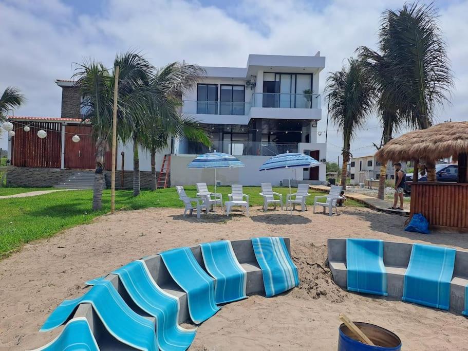 蒙塔尼塔Hermosa casa frentes al mar en Montanita con piscina的海滩上的一组椅子和遮阳伞
