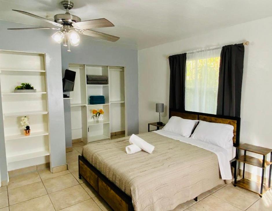 哈兰代尔海滩Hallandale Beach Motel的一间卧室配有一张大床和吊扇