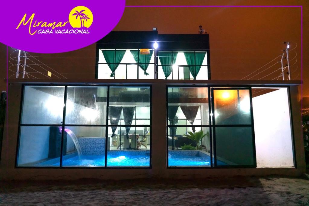 通苏帕MIRAMAR Casa Vacacional Frente al mar的夜间带游泳池的别墅